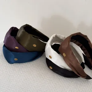 Detailed view of vintage wide padded headbands with gold labels in various elegant colors.
