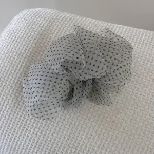 Detail view of the elegant polka dot seersucker hair claw clip with ruffled mesh.