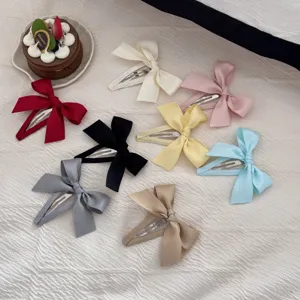 Collezione colorata di fermagli per capelli con fiocco in tessuto stile coreano su stoffa.
