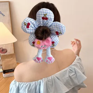 Close-up of cute blue checkered flower scrunchie with pink plush cat on a hair bun