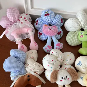 Close-up of various cute plush flower hair scrunchies with soft fabric and cartoon details.