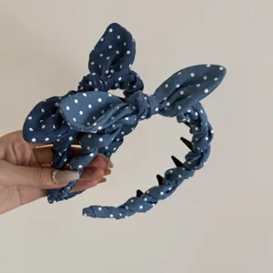 Detalle de diadema azul de lunares con lazos de orejas de conejo y dientes antideslizantes