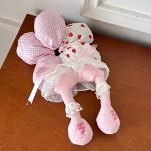 Close-up detail of a cute plush flower hair scrunchie with decorative legs and lace trim