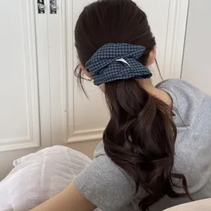Close-up back view of a blue and black checkered scrunchie styling a wavy ponytail