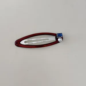 Vue détaillée de l'élégante décoration en perles et zircon bleu sur la barrette rouge