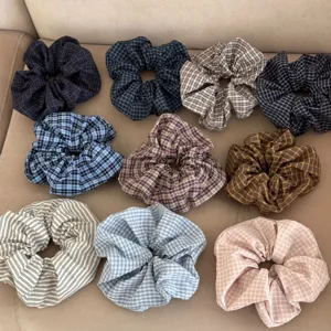 Collection of colorful plaid and striped oversized scrunchies presented on a neutral background