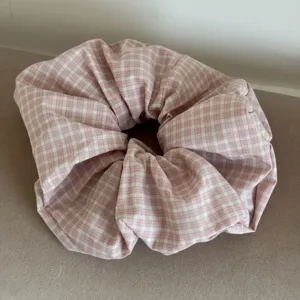 Detailed macro view of purple pink plaid fabric texture on a large scrunchie hair tie