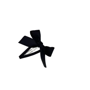 Elegante fermaglio per capelli con fiocco in nastro nero e chiusura argento su fondo bianco