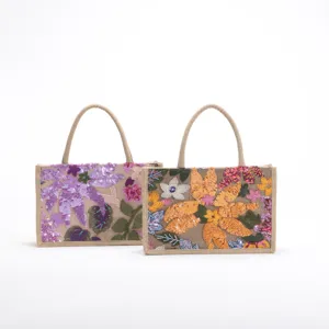 Detailed view of vibrant floral sequin embroidery on rustic woven jute tote bags
