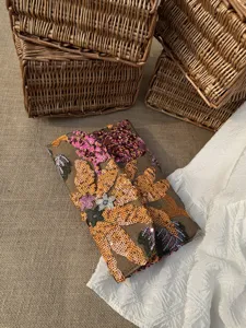 Detailed close-up of a floral sequin embroidered envelope clutch for evening events.