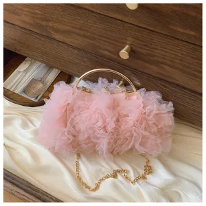 Detail of pink ruffled tulle evening clutch bag with gold handle and chain strap