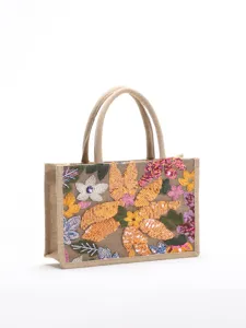 Macro view of vibrant floral sequin embroidery on the front of a burlap tote handbag