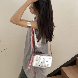 Bolso bandolera plateado con diamantes de colores y correa rosa en una modelo asiática.