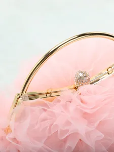 Dettaglio di una romantica pochette da sera in rete plissettata rosa con chiusura a sfera