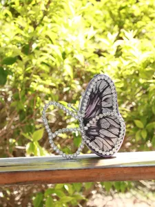 Pochette de soirée papillon élégante avec bordures en strass et imprimé d'aile violette.