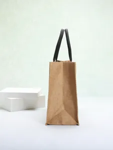 Side view of a minimalist eco-friendly burlap tote bag with black handles.