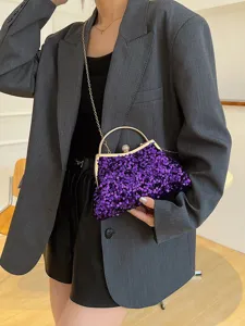 Detaillierte Ansicht einer lila Pailletten-Tasche, getragen von einem Model im Blazer