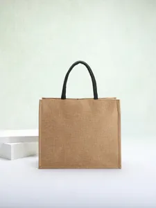 Detailed view of eco-friendly natural jute tote bag featuring sturdy black handles