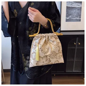 Detailed view of floral embroidery and bamboo handles on elegant evening handbag