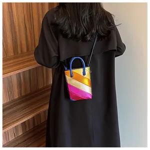 Focus on the metallic rainbow patchwork texture of the mini bucket bag worn by model