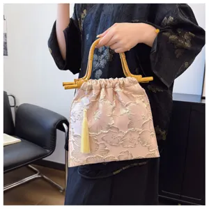 Elegant pink jacquard evening handbag with bamboo handle and decorative tassel