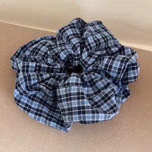 Detailed close-up view of a blue and navy plaid oversized scrunchie on a neutral background