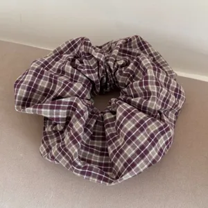 Macro view of a purple and beige checkered fabric hair scrunchie for sweet hairstyles