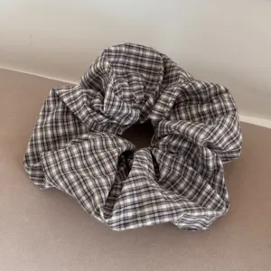 Detailed close-up of a sweet purple and pink plaid fabric hair scrunchie
