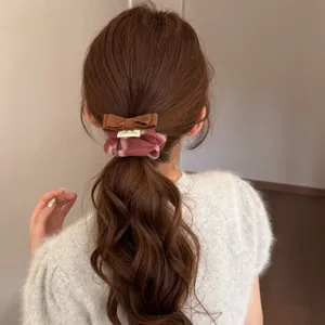 Detailed view of a retro plaid bow scrunchie styling a ponytail