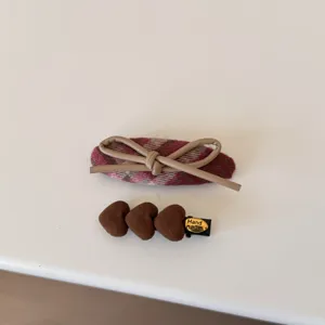 Detail view of a vintage plaid hair clip with bow and brown fabric heart hairpin