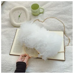 Elegant white tulle ruffled evening handbag featuring a stylish gold circular metal handle