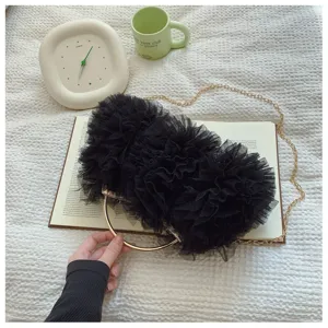 Detailed view of the black mesh ruffle evening clutch with gold ring handle