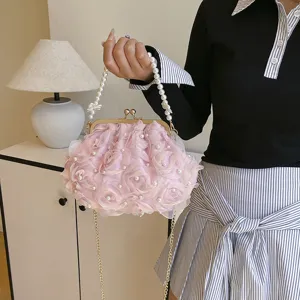 Gros plan sur les roses en tissu rose et la poignée en perles du sac à main chic