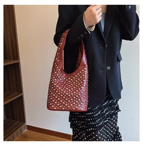 Close-up of a women's punk style bucket bag featuring shiny silver round rivet studs.