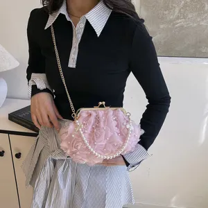 Modèle portant une pochette rose à fleurs 3D avec perles et détails de chaîne