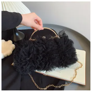 Close-up of black mesh ruffle evening handbag with elegant gold handle