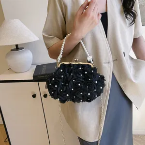 Sac à bandoulière noir élégant avec fleurs et poignée en perles porté par un mannequin chic.