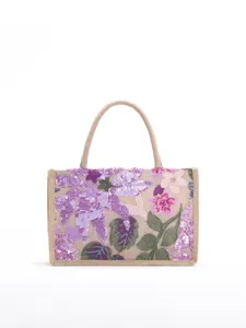 Front view of a jute tote bag with intricate floral sequin embroidery and dual handles