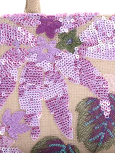 Detailed macro view of intricate purple floral sequin embroidery on a luxury woven tote bag