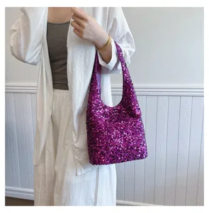 Close-up of a vibrant purple sequined shoulder bag styled with a white casual outfit