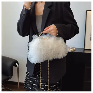 Detail view of white ruffled mesh evening clutch with gold metal handle and chain