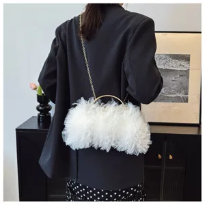 White ruffled lace evening clutch bag shown on a model's shoulder with gold handle