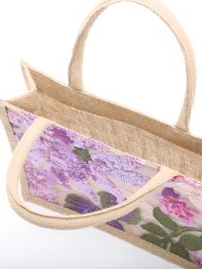 Close-up view showing elegant purple floral sequin embroidery on natural jute tote bag