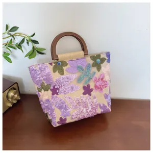Dettaglio borsa in lino ricamata a fiori con manici circolari in un set retrò
