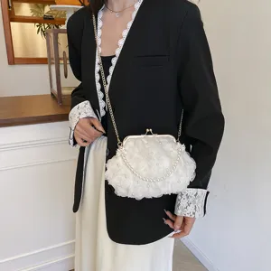 Détail du sac à main fleuri blanc avec perles et chaîne dorée pour un look sophistiqué