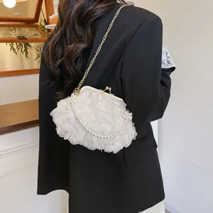 Sac à fleurs rose blanc élégant avec perles et chaîne dorée porté avec un blazer.