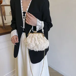 Détail d'une pochette de soirée à perles et fleurs crème avec bandoulière chaîne dorée