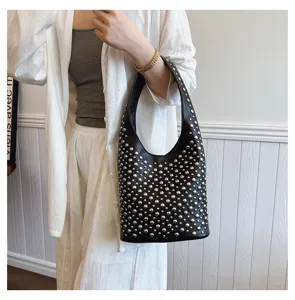 Close-up detail of punk style black bucket bag with silver rivet studs for women