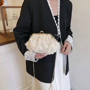 Gros plan d'un sac sous les aisselles à fleurs blanches avec bandoulière perles