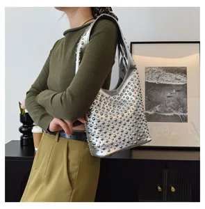 Modern silver hobo shoulder bag featuring all-over round metallic studs on model